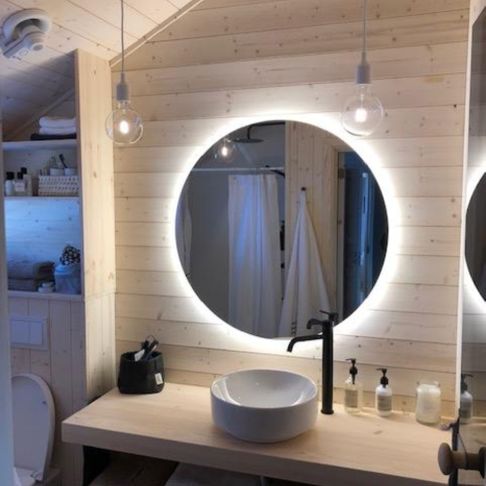 Lyst og moderne bad med trevegger, toalett, vask, speil og diverse småting