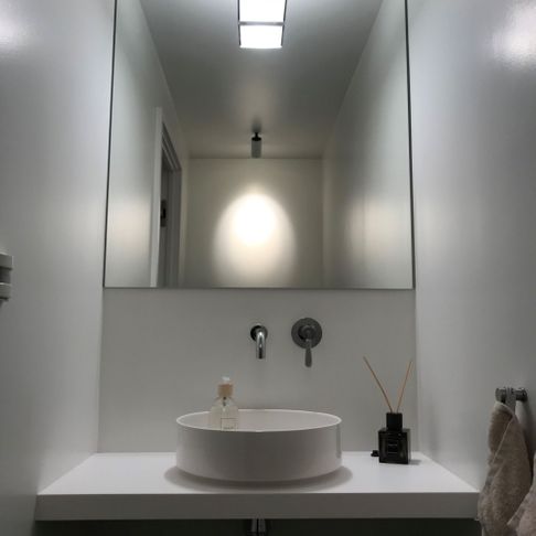 Moderne bad med god belysning, speil, vask, håndduk