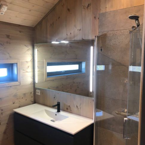 Lyst moderne bad med speil, vindu, vask og dusj